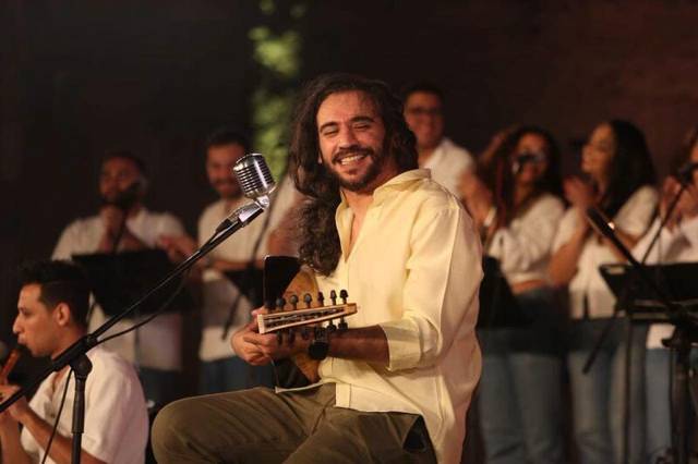 سعد العود بيبتسم بالعود وسط الفرقة